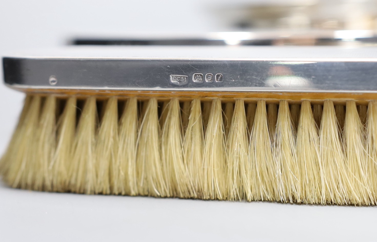 A 1960's seven piece engine turned silver backed brush, mirror and powder bowl set.